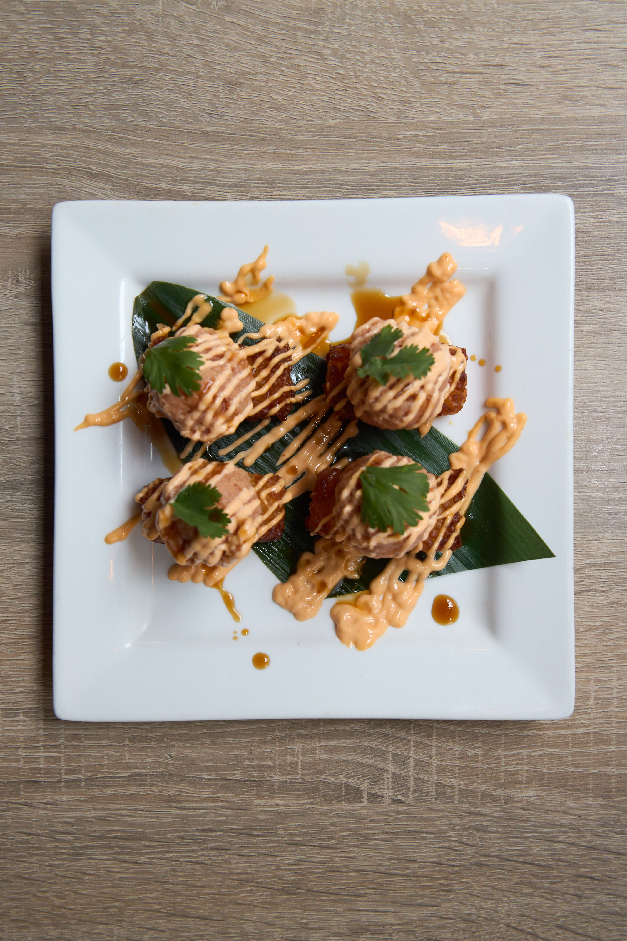 Aburi bites overhead on white plate with banana leaf