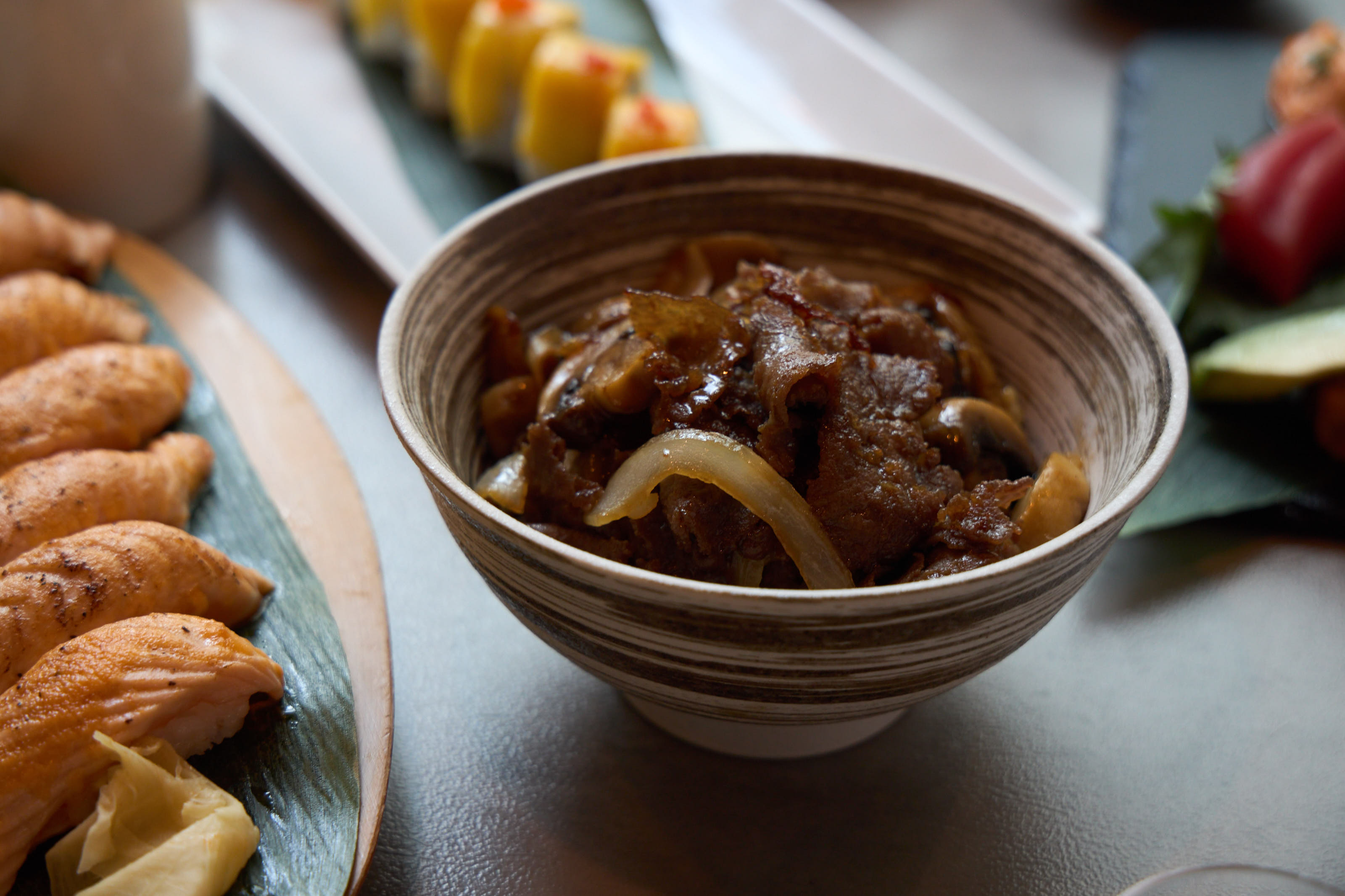 Beef teriyaki bowl with mushrooms and onion over rice in ceramic bowl