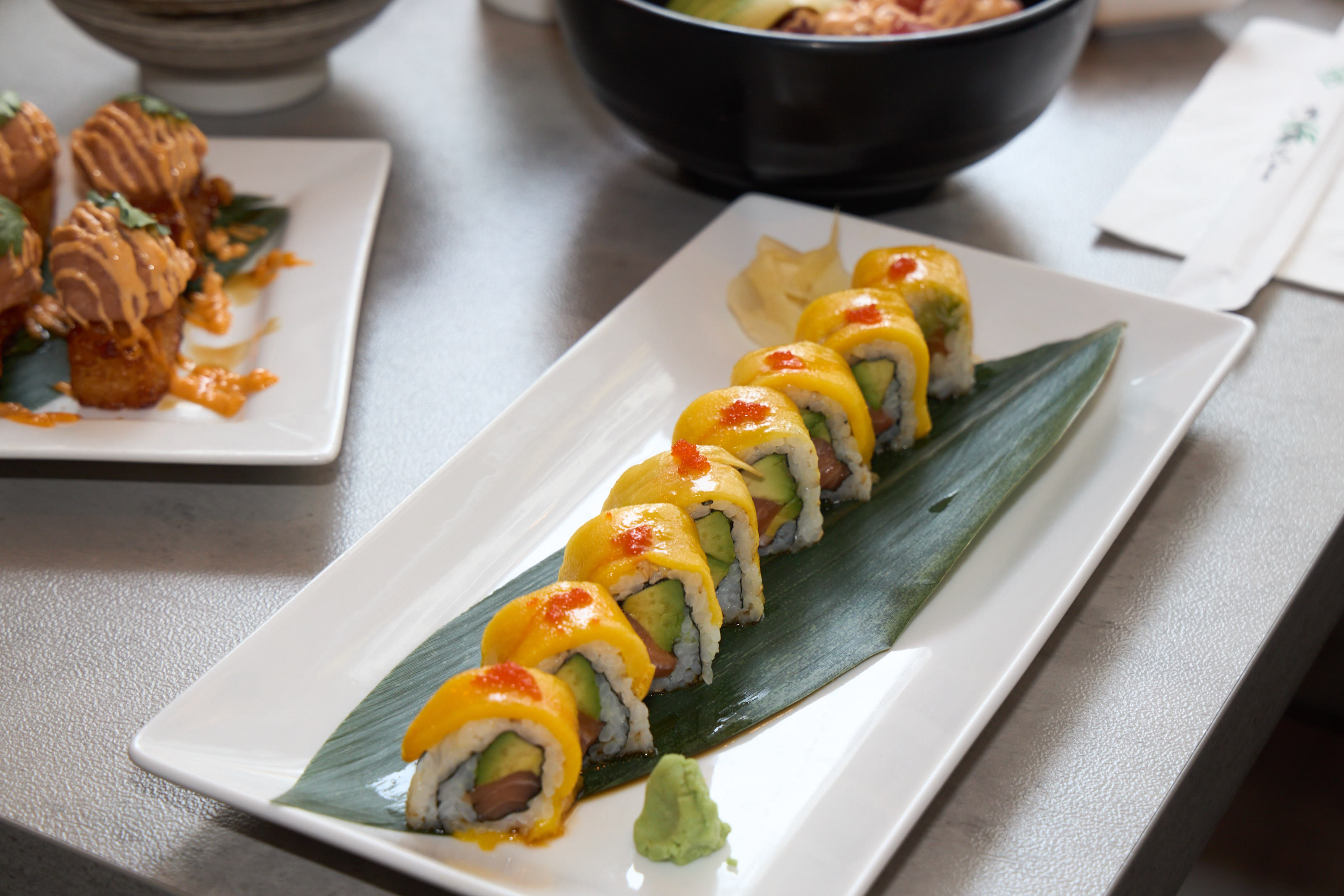 Mango Volcano Roll with tobiko on a banana leaf