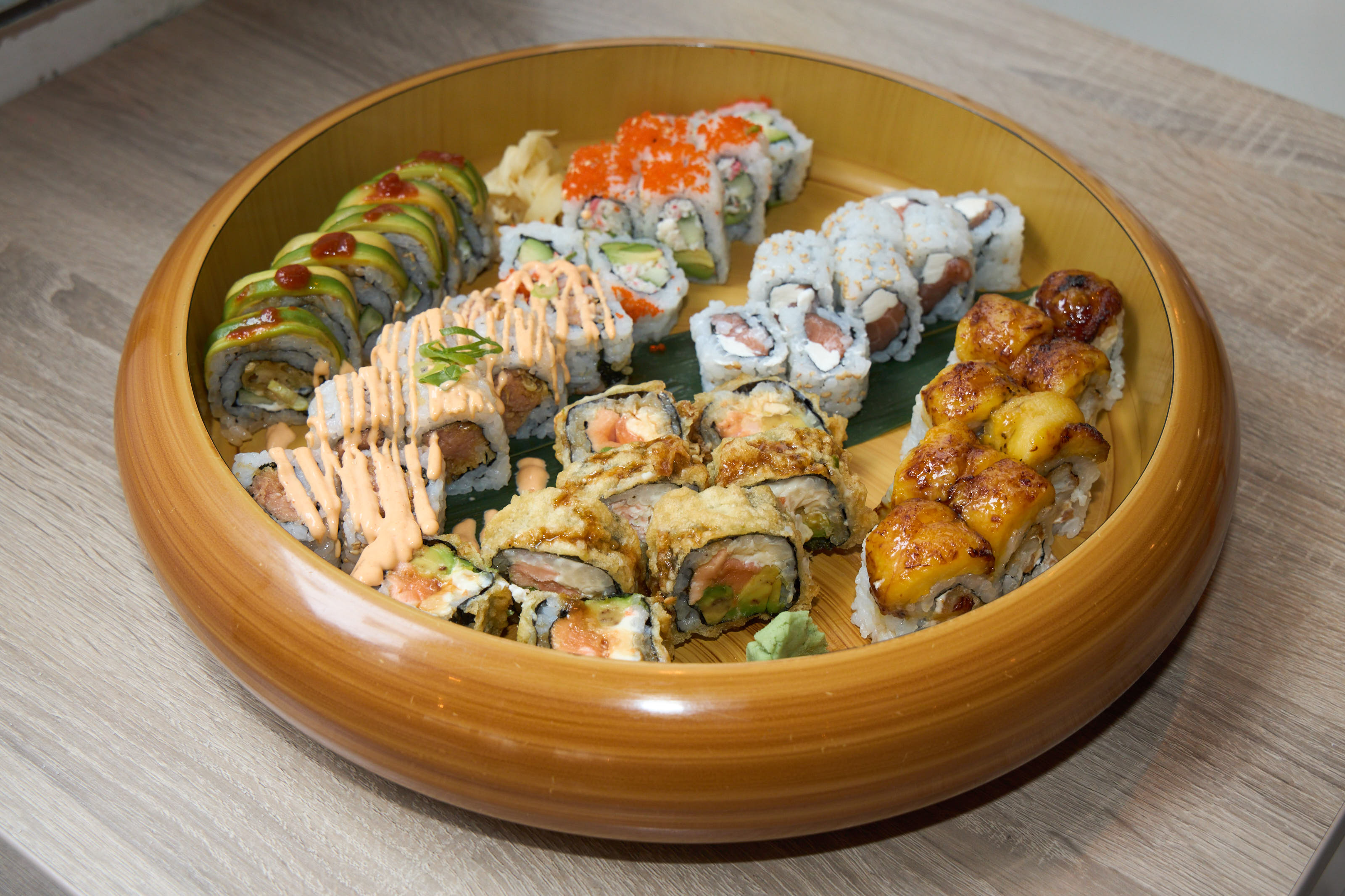 Round gold platter filled with assorted specialty rolls