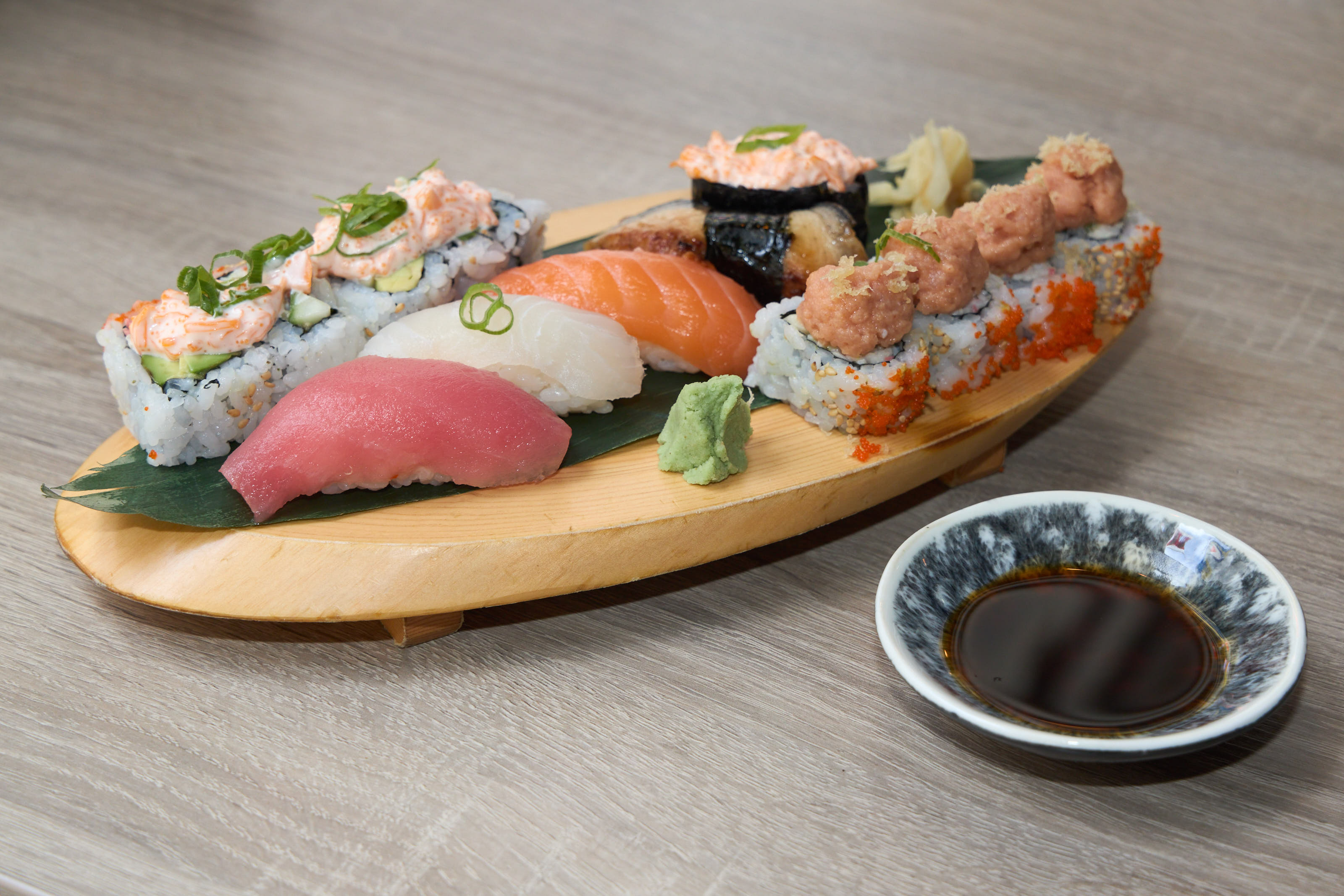 Mixed sushi boat with tuna nigiri, salmon nigiri and specialty rolls